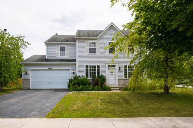 a front view of a house with a yard and a garage
