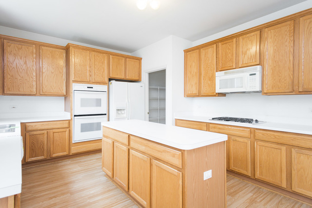 1605 Manhattan Street Bolingbrook, IL 60490 - Photo 16 of 29 a kitchen with stainless steel appliances white cabinets and wooden floors