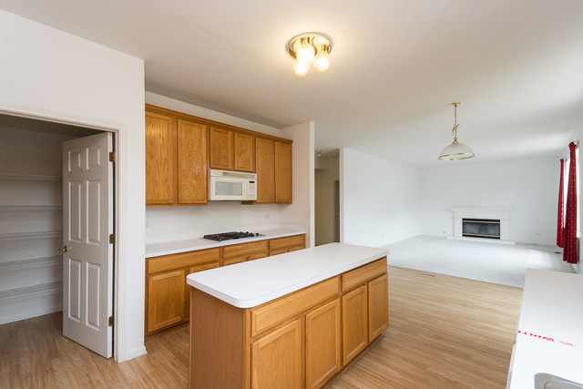 1605 Manhattan Street Bolingbrook, IL 60490 - Photo 19 of 29 a kitchen with stainless steel appliances granite countertop a sink a stove and a refrigerator