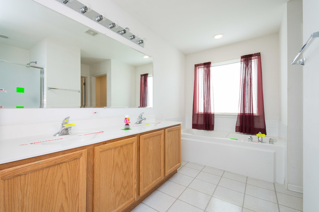 1605 Manhattan Street Bolingbrook, IL 60490 - Photo 23 of 29 a bathroom with a bathtub sink and mirror