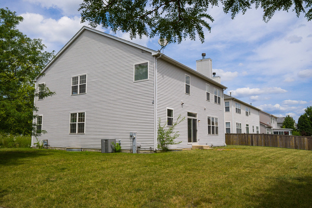 1605 Manhattan Street Bolingbrook, IL 60490 - Photo 5 of 29 a view of a white house next to a yard with plants and trees