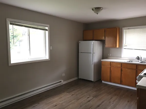 a kitchen with a refrigerator window and wooden floor
