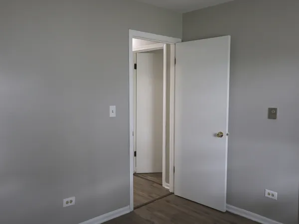 an empty room with wooden floor and entrance