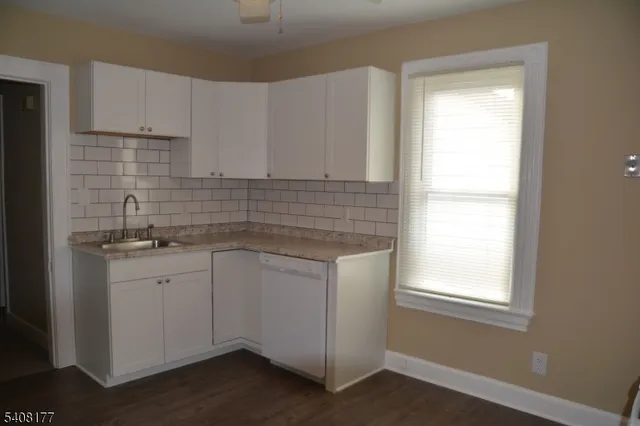 a kitchen with granite countertop white cabinets and white appliances