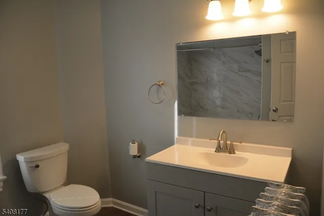 a bathroom with a sink toilet and mirror
