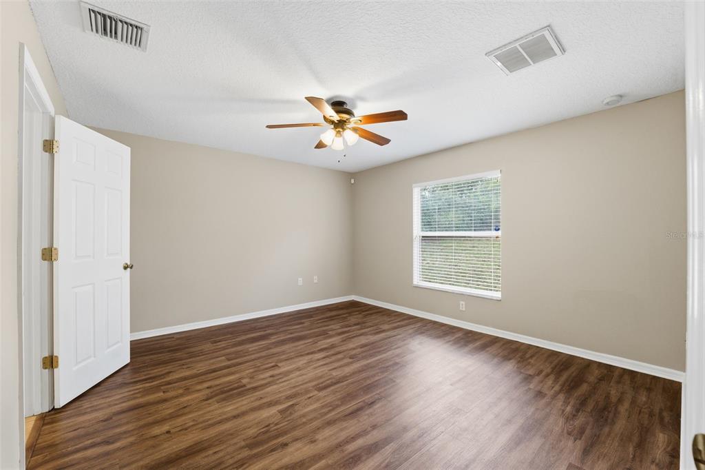13477 Amanda Avenue Spring Hill, FL 34609 - Photo 14 of 46 an empty room with wooden floor and windows