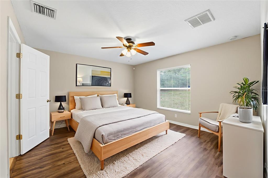 13477 Amanda Avenue Spring Hill, FL 34609 - Photo 15 of 46 a bedroom with a bed and a potted plant on the dresser