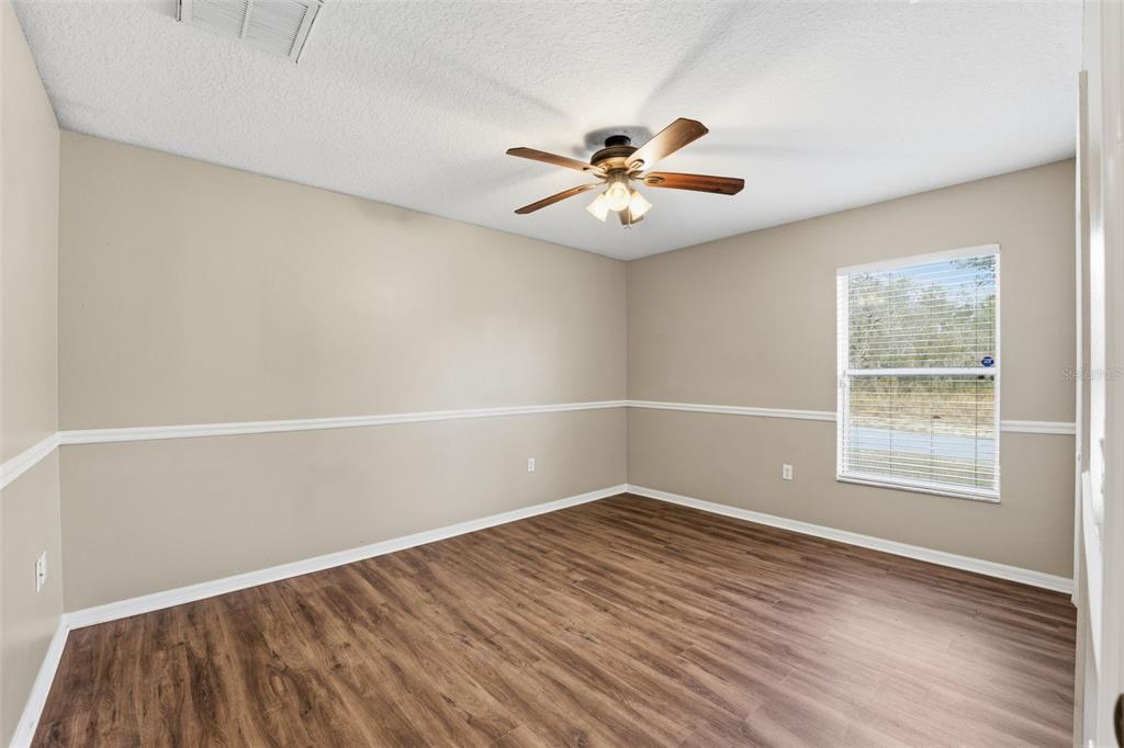 13477 Amanda Avenue Spring Hill, FL 34609 - Photo 18 of 46 an empty room with wooden floor and windows