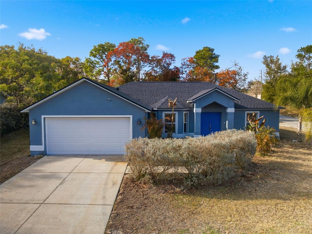 13477 Amanda Avenue Spring Hill, FL 34609 - Photo 2 of 46 a front view of a house with a yard and garage