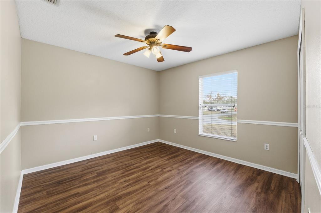 13477 Amanda Avenue Spring Hill, FL 34609 - Photo 21 of 46 an empty room with wooden floor fan and windows