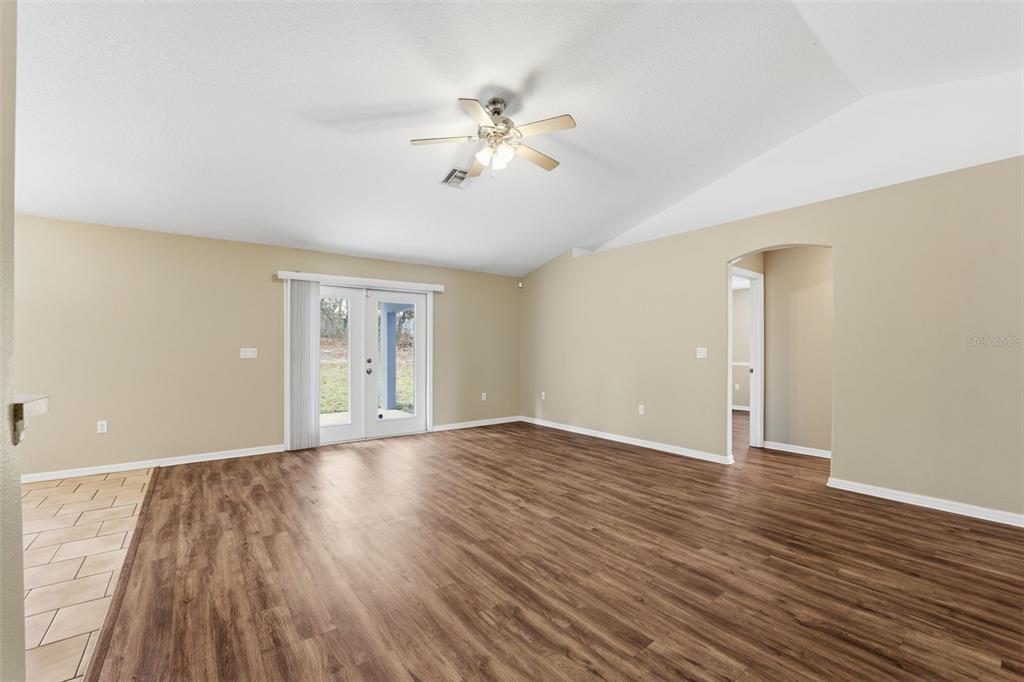 13477 Amanda Avenue Spring Hill, FL 34609 - Photo 36 of 46 a view of an empty room with wooden floor and a ceiling fan