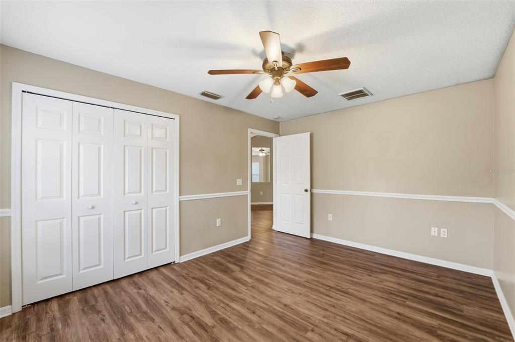 13477 Amanda Avenue Spring Hill, FL 34609 - Photo 45 of 46 an empty room with wooden floor a ceiling fan and closet