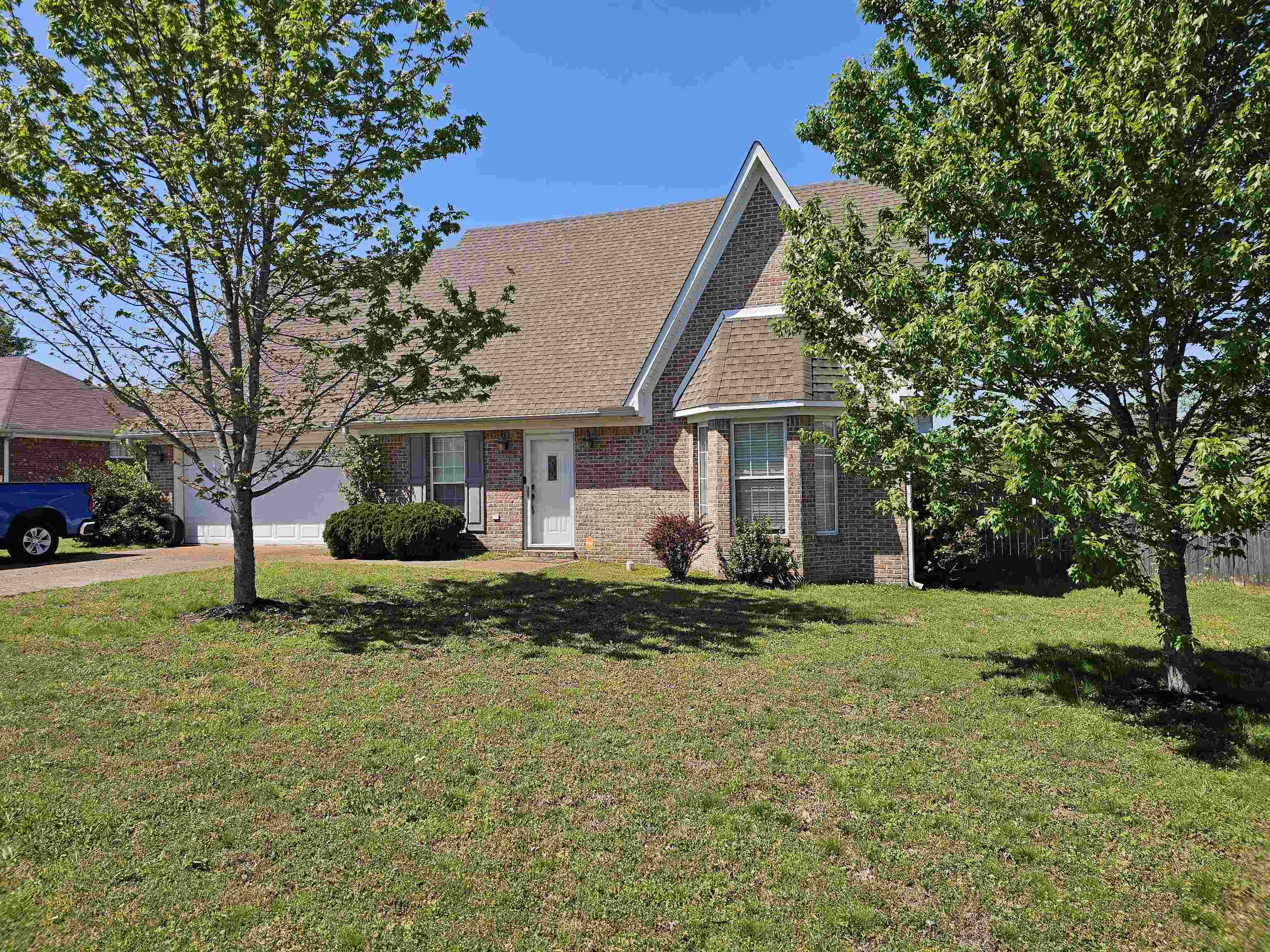 109 Sebastian Drive Jackson, TN 38305 - Photo 2 of 24 View of front of property with brick siding, roof with shingles, a front yard, and an attached garage