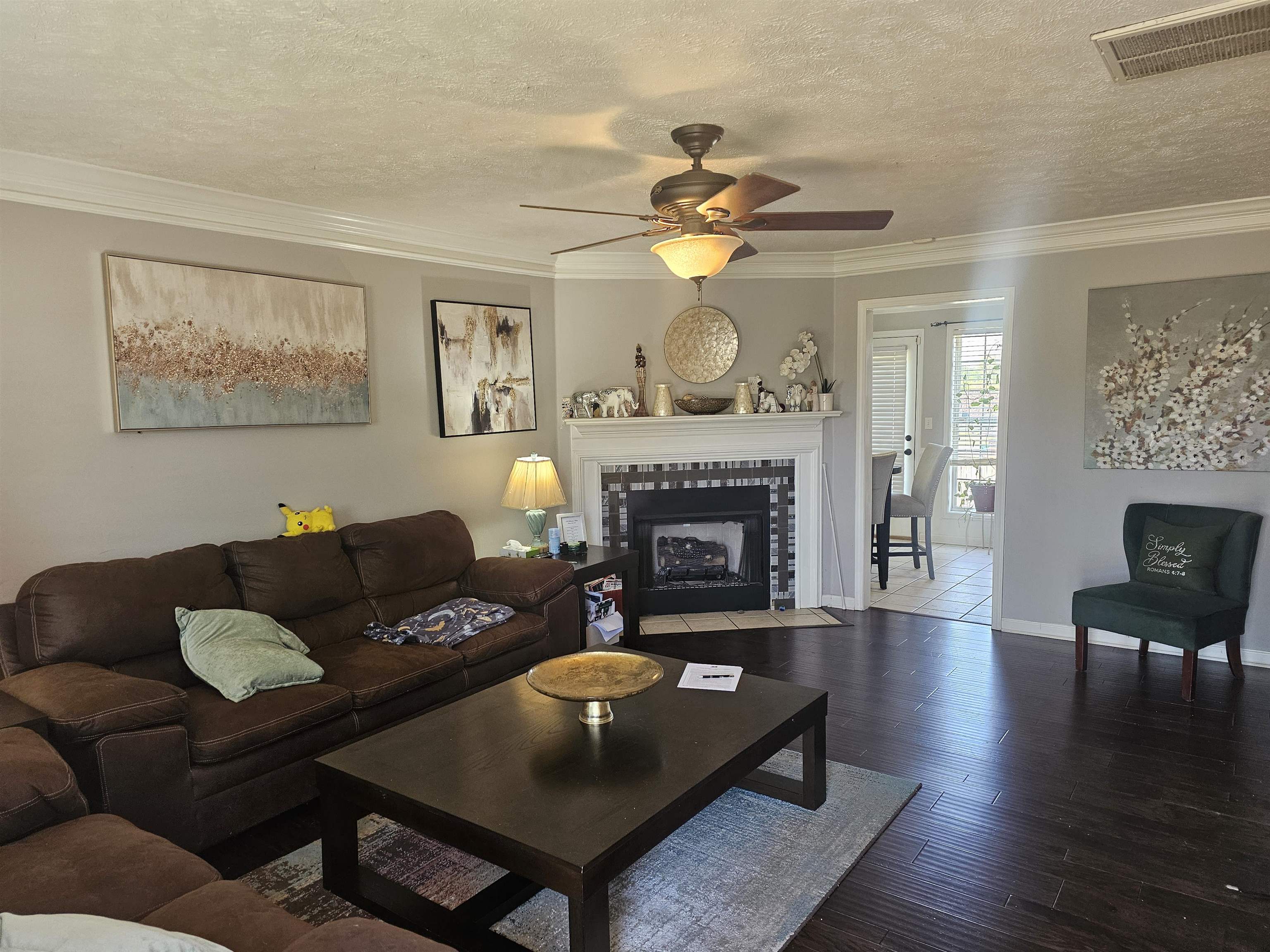 109 Sebastian Drive Jackson, TN 38305 - Photo 4 of 24 Living room featuring a ceiling fan, a textured ceiling, wood finished floors, crown molding, and a fireplace