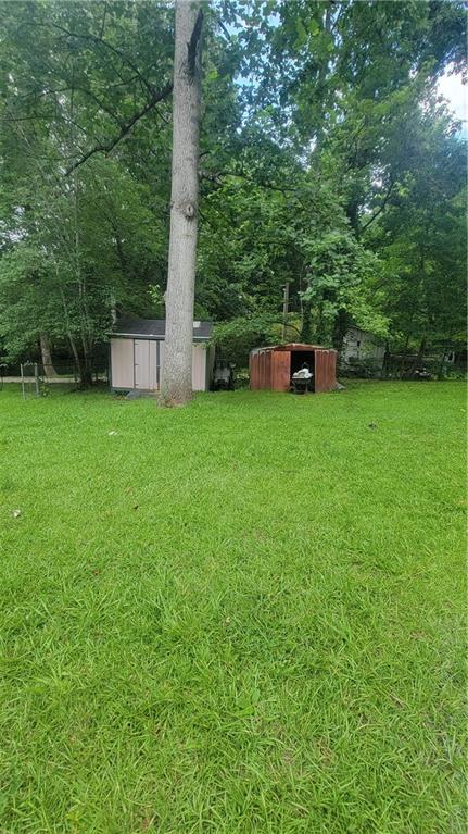 174 Luther Circle Villa Rica, GA 30180 - Photo 31 of 32 a backyard of a house with plants and large trees