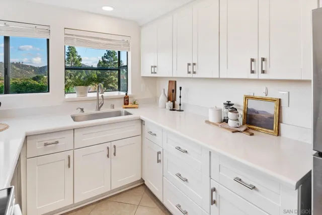 a kitchen with white cabinets and white appliances