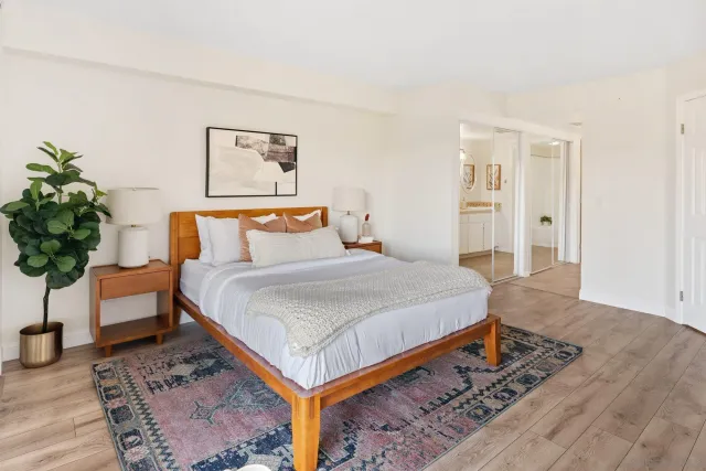 a bedroom with a bed and a potted plant