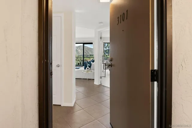 a view of a hallway with wooden floor and a living room