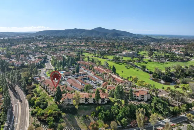 an aerial view of green landscape with trees houses and mountain view