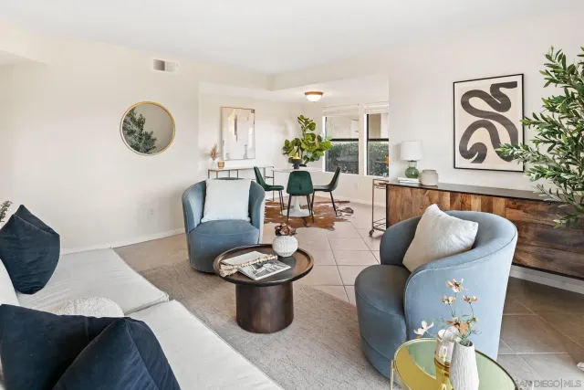 a living room with furniture a rug and wall paintings
