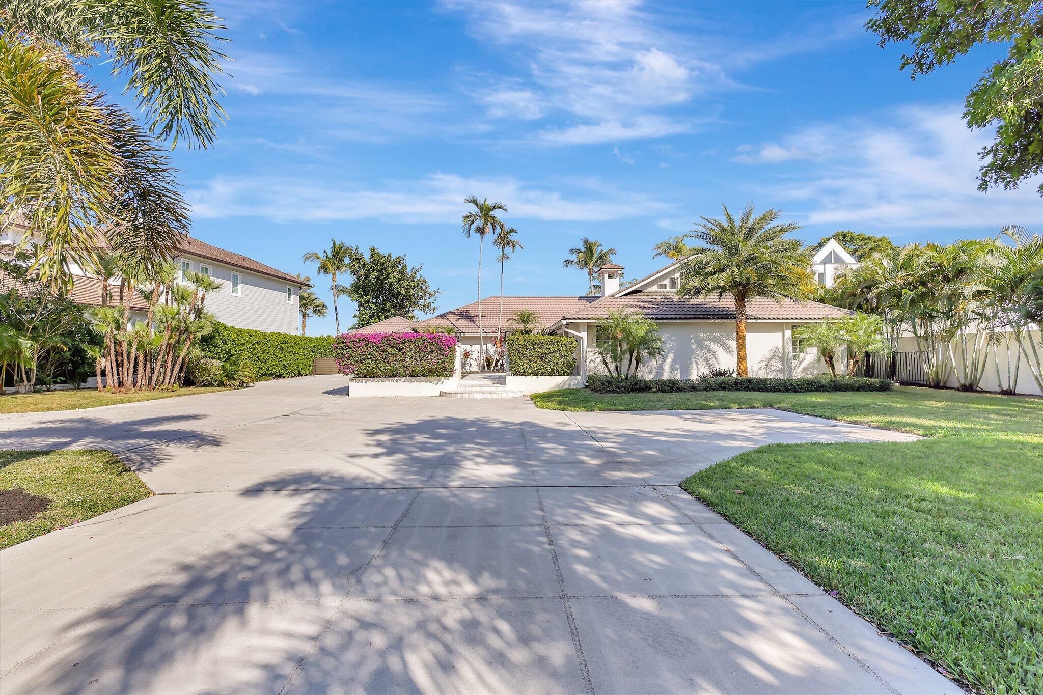 18896 Point Drive Tequesta, FL 33469 - Photo 13 of 62 a front view of a house with a yard and garage