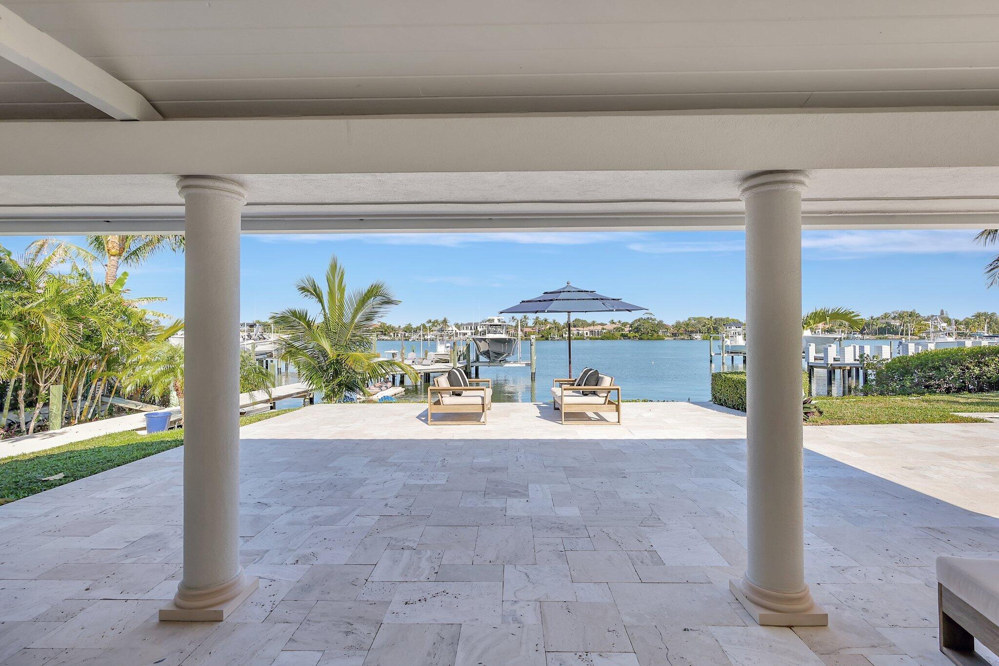 18896 Point Drive Tequesta, FL 33469 - Photo 33 of 62 a view of a balcony with table and chairs potted plants