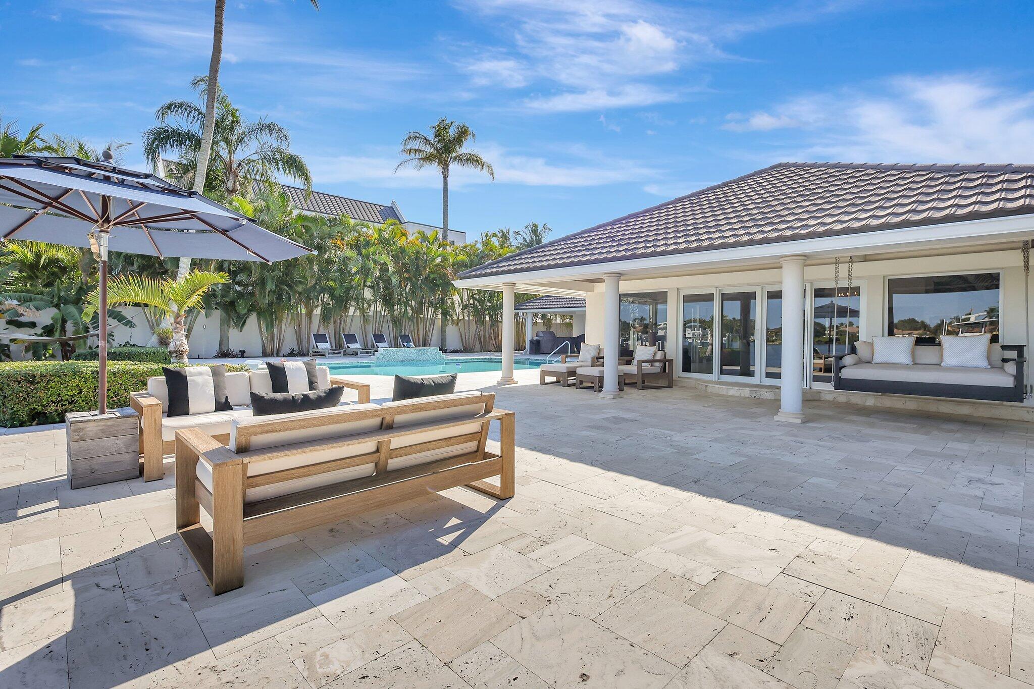 18896 Point Drive Tequesta, FL 33469 - Photo 36 of 62 a view of a patio with table and chairs under an umbrella
