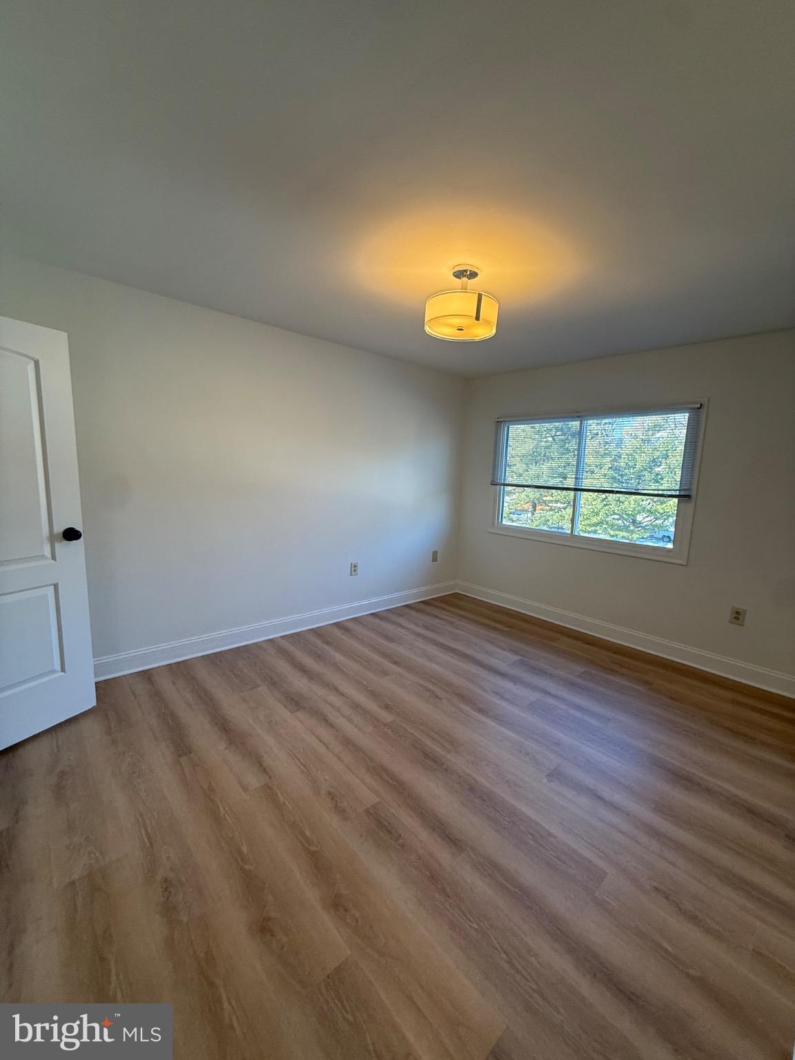 3842 Bel Pre Road, Unit 12 Silver Spring, MD 20906 - Photo 9 of 14 an empty room with wooden floor and windows
