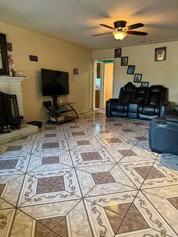 a living room with patio furniture and a flat screen tv
