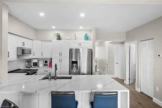 a kitchen with stainless steel appliances kitchen island granite countertop a refrigerator and a stove top oven