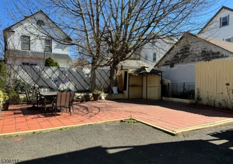 70 Elliot Street, Unit 1 Passaic, NJ 07055 - Photo 15 of 15 a view of a backyard with table and chairs with wooden fence