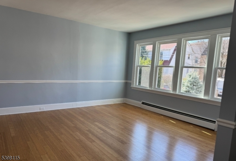 70 Elliot Street, Unit 1 Passaic, NJ 07055 - Photo 5 of 15 wooden floor in an empty room with a window