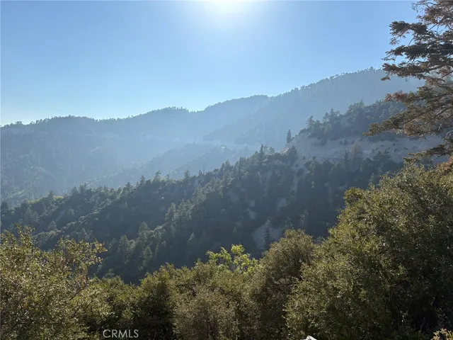 a view of a mountain range with lush green forest