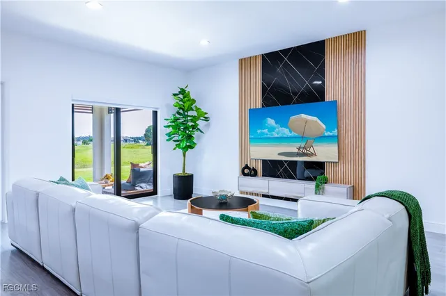 a large living room with stainless steel appliances kitchen island granite countertop a large kitchen island a stove and a refrigerator