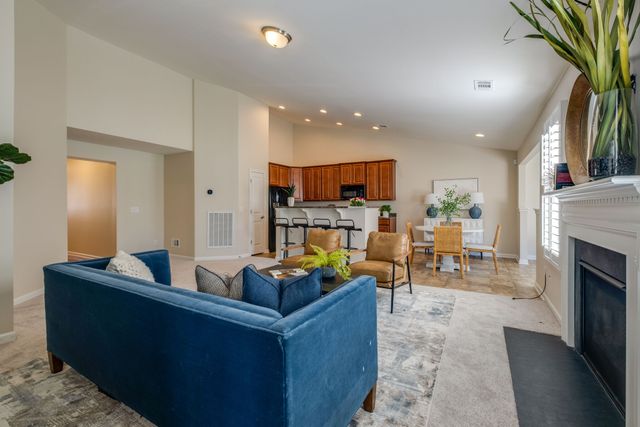 a living room with fireplace furniture and a potted plant