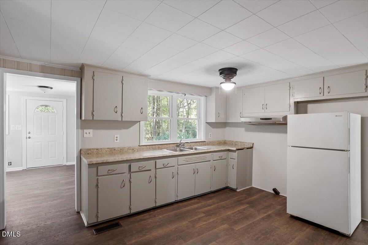 2008 Angier Road Fuquay-Varina, NC 27526 - Photo 15 of 34 a kitchen with a sink a refrigerator and white cabinets