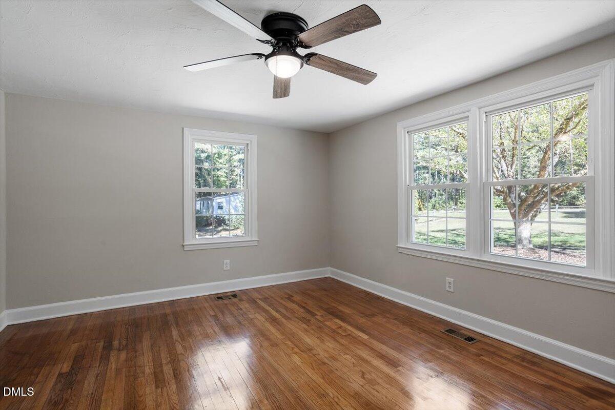 2008 Angier Road Fuquay-Varina, NC 27526 - Photo 19 of 34 a view of an empty room with wooden floor and a window