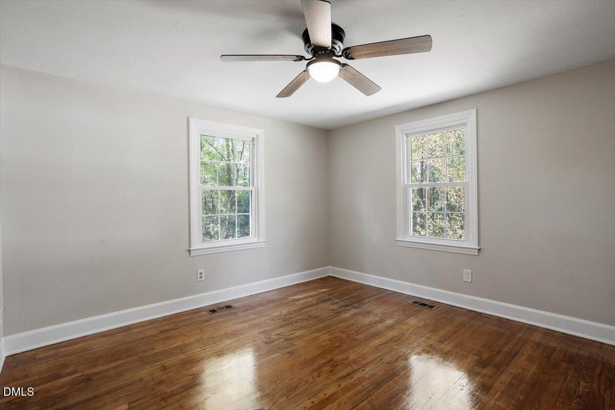 2008 Angier Road Fuquay-Varina, NC 27526 - Photo 22 of 34 a view of an empty room with wooden floor and a window