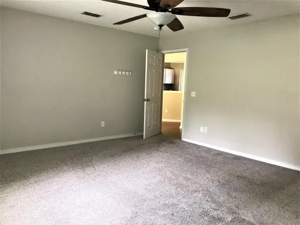 en empty room with windows and fan