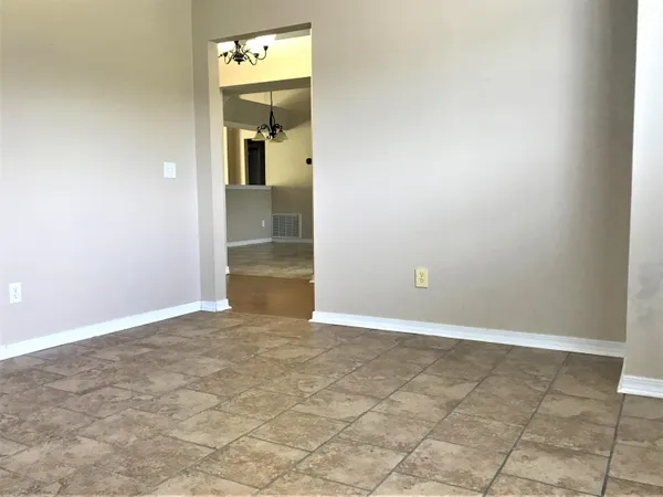 an empty room with a bathroom and mirror