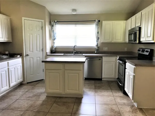a kitchen with a sink stove top oven and cabinets