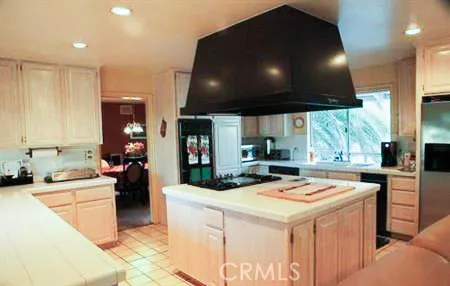 a kitchen that has a sink a stove and a table with wooden floor