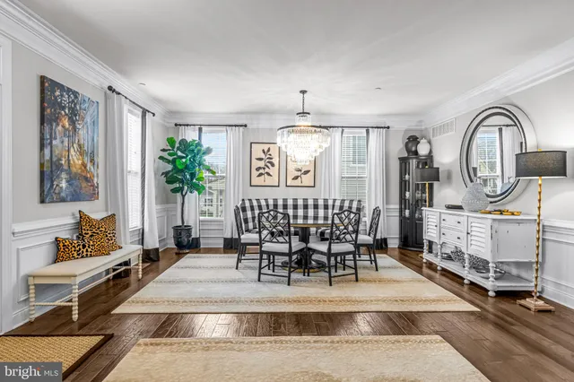 a view of a livingroom with furniture a chandelier and wooden floor