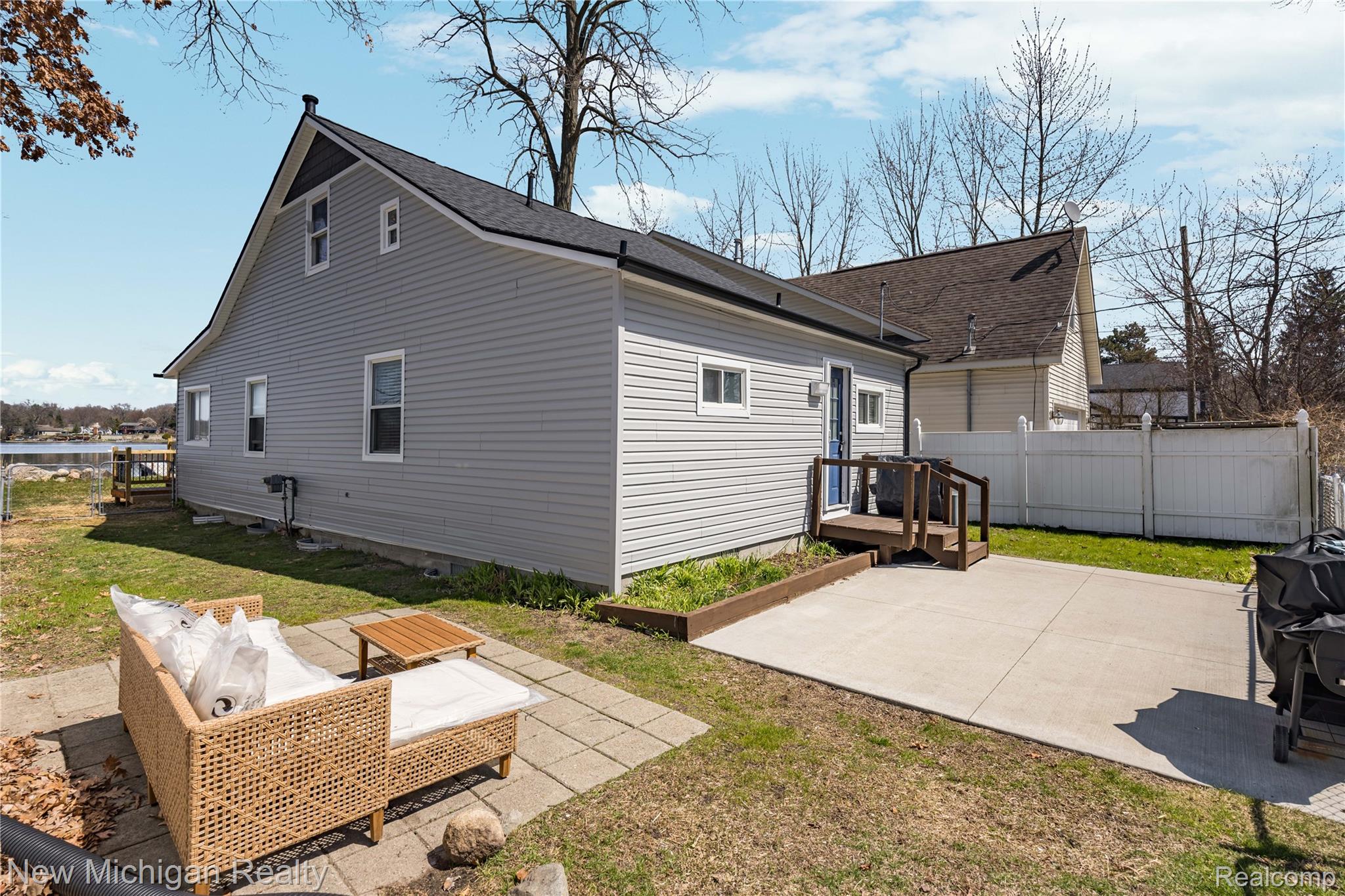8665 Cooley Lake Road Commerce Township, MI 48382 - Photo 45 of 52 View of property exterior with a patio and outdoor seating