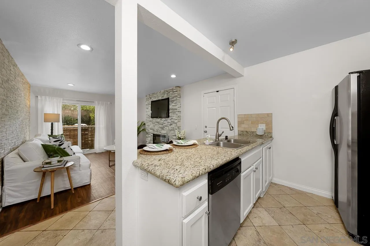 9860 Dale Avenue, Unit C3 Spring Valley, CA 91977 - Photo 8 of 26 a kitchen with stainless steel appliances granite countertop a sink counter space and living room view