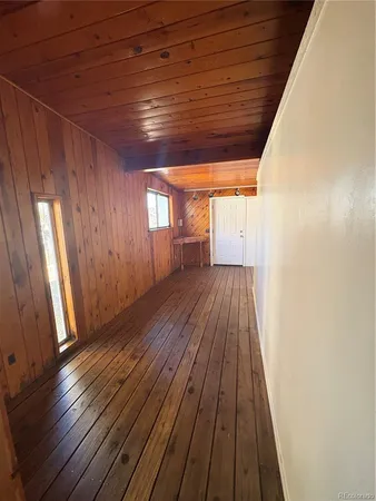 a view of a room with wooden floor and window