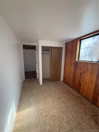 an empty room with windows and closet