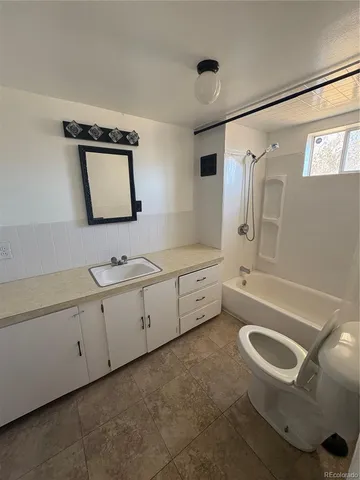 a bathroom with a double vanity sink a toilet a mirror and bathtub