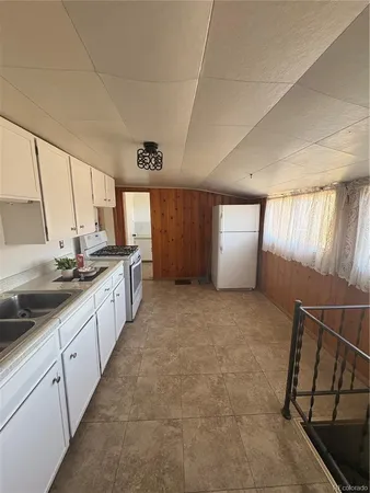 a large white kitchen with a sink and cabinets