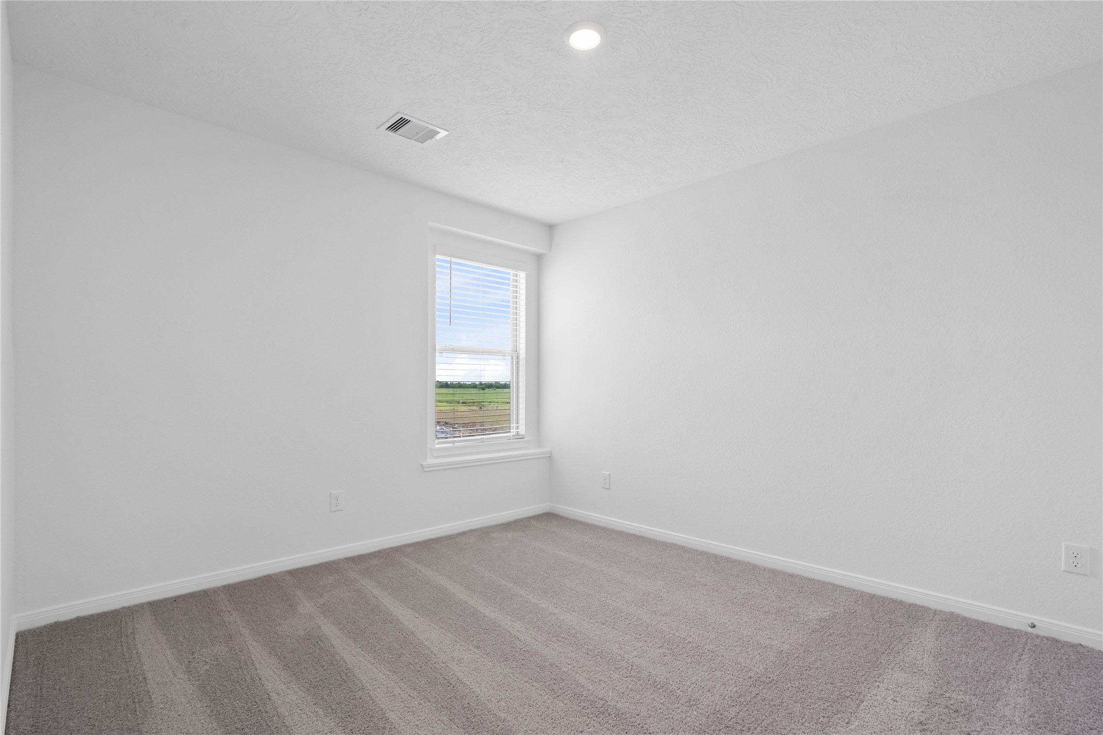 7210 Brooklea Road Beasley, TX 77417 - Photo 24 of 32 This secondary bedroom offers comfort and style with plush carpeting, neutral paint tones, recessed lighting, large window with blinds, and a generously sized closet.